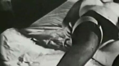 Дівчина в ліжку в сексуальних чорних панчохах (вінтаж 1960-х років)